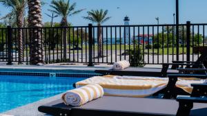 a swimming pool with a table with towels on it at The Markham Hotel in Gulfport