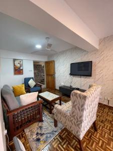 a living room with a couch and a tv at The Olive Homes in Nairobi +10 photos