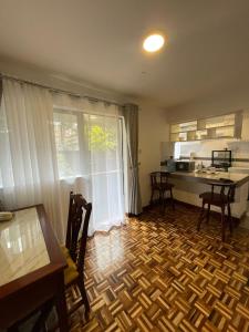 a kitchen with a wooden floor with a table and a counter at The Olive Homes in Nairobi