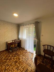 a room with a table and chairs and a window at The Olive Homes in Nairobi