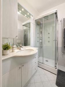 a white bathroom with a sink and a shower at Ninfa del lago - PRIVATE GARAGE in Colico +6 photos
