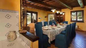 a dining room with a long table and blue chairs at Umbria Genius Loci Farmhouse in Gaglietole