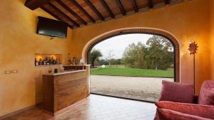 an archway in a room with a bar with a view of a field at Umbria Genius Loci Farmhouse in Gaglietole