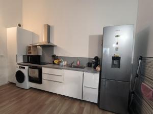 a kitchen with a stainless steel refrigerator and a sink at Maison Tarnos in Tarnos