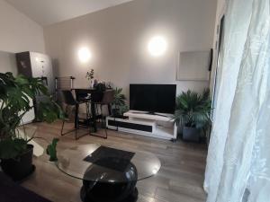 a living room with a flat screen tv and a table at Maison Tarnos in Tarnos