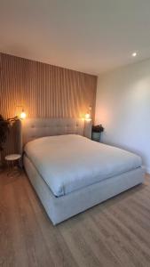 a bedroom with a large white bed with two lights at Privé studio in groene omgeving van Brugge gratis fietsen & parkeerplaats in Bruges