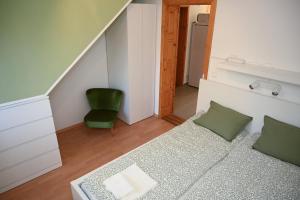 a small room with a couch and a green chair at Bogárka Apartmanház in Siófok +5 photos