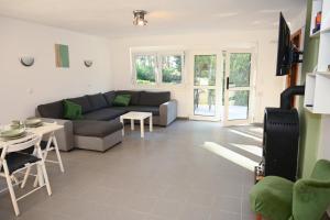 a living room with a couch and a table at Bogárka Apartmanház in Siófok