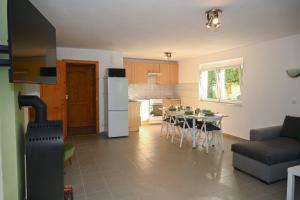 a kitchen and living room with a table and a refrigerator at Bogárka Apartmanház in Siófok