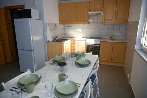 a kitchen with a table with green dishes on it at Bogárka Apartmanház in Siófok
