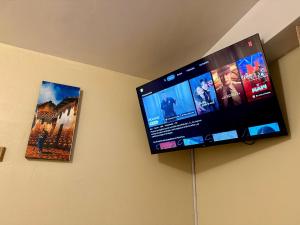 a flat screen tv hanging on a wall with two pictures at Hospedaje el Indi0 in Pisac