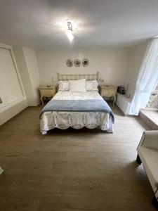 a bedroom with a bed with a blue blanket at La Casa del Río in Porto do Son +16 photos