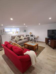 a living room with a red couch and a tv at La Casa del Río in Porto do Son