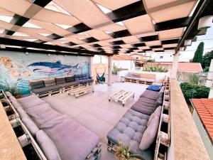 a large patio with couches and tables and a mural at Backpackers Home in Zadar +33 photos