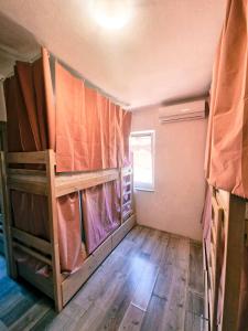 a small room with bunk beds and a wooden floor at Backpackers Home in Zadar