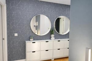 two mirrors above a white dresser in a bathroom at La Bahía in Baiona