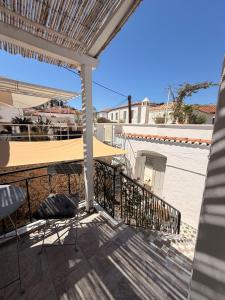 a balcony with a table and chairs and a building at ΑtoZ studio in Hydra in Hydra