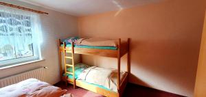 two bunk beds in a room with a window at FEWO Aschbergblick in Klingenthal