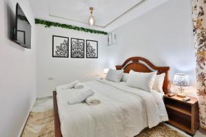 a bedroom with a large white bed with white sheets at A&C Blue Haven in Chefchaouen