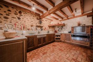 a large kitchen with wooden cabinets and appliances at Casona del Tambor in Calatañazor