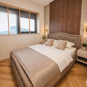a bedroom with a large bed and a window at Olszynki Park Elite Residence in Rzeszów +12 photos
