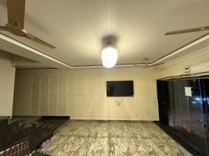 an empty room with a flat screen tv on the wall at The Mukhiya Palace in Govardhan