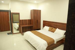 a bedroom with a large bed and a mirror at The Mukhiya Palace in Govardhan