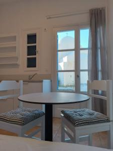 a kitchen with a table and two chairs and a window at Paraporti in Chora Folegandros +74 photos