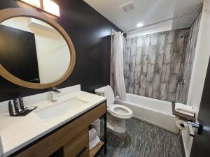 a bathroom with a sink and a toilet and a mirror at Penn Lodge Hotel & Suites Philadelphia - Bensalem in Bensalem +12 photos