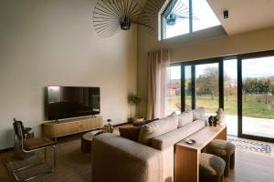 a living room with a couch and a flat screen tv at Wolne Domy in Dominikowice