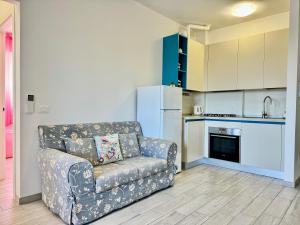 a living room with a couch and a kitchen at 80 Trilocale al Barbara in Lido Adriano