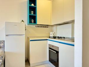 a kitchen with white cabinets and a white refrigerator at 80 Trilocale al Barbara in Lido Adriano