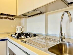 a kitchen with a stove and a sink at 80 Trilocale al Barbara in Lido Adriano +31 photos
