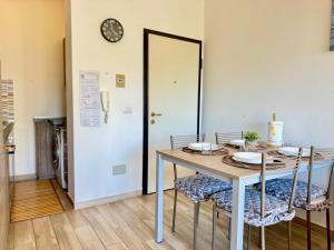 a dining room table with chairs and a clock on the wall at Alabastro 40 in Lido Adriano