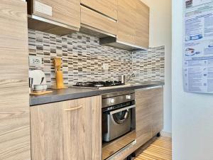 a kitchen with wooden cabinets and a stove top oven at Alabastro 40 in Lido Adriano