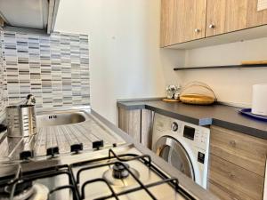 a kitchen with a stove top oven next to a washing machine at Alabastro 40 in Lido Adriano