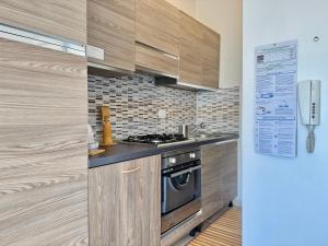 a kitchen with wooden cabinets and a stove at Alabastro 40 in Lido Adriano +26 photos