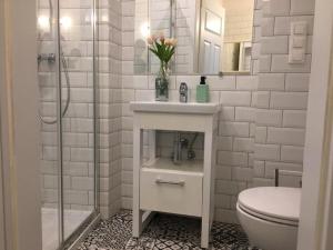 a bathroom with a toilet and a vase of flowers at GREEN HOUSE Hostel in Krakow +21 photos
