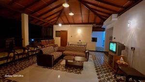 a living room with a couch and a tv at Nature View Villa in Badulla