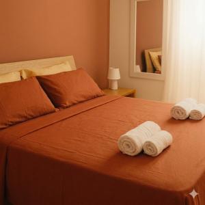 a bedroom with a bed with two towels on it at Torres House Suite & Rooms in Sassari