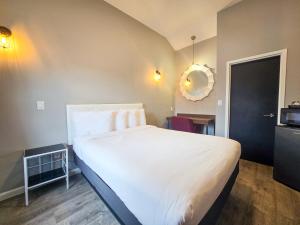 a bedroom with a large bed with white sheets at Penn Lodge Hotel & Suites Philadelphia - Bensalem in Bensalem