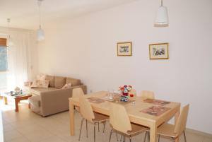 a dining room with a table and chairs and a couch at Secret Arcadia Bay - Maisonette Breathtaking sea & mountain view-Just on the beach in Áyios Andréas
