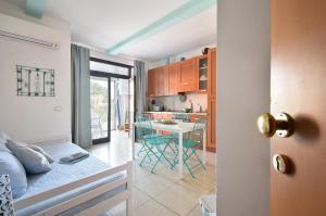 a room with a bed and a kitchen with a table at Piccolo Loft Sabbia e Sassi in Marina di San Vito