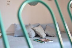 a bed with pillows and a book on it at Piccolo Loft Sabbia e Sassi in Marina di San Vito