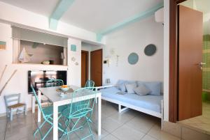 a living room with a couch and a table and chairs at Piccolo Loft Sabbia e Sassi in Marina di San Vito