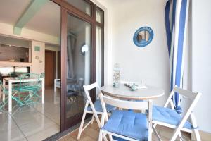a dining room with a white table and chairs at Piccolo Loft Sabbia e Sassi in Marina di San Vito