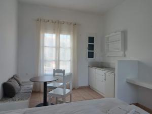 a white kitchen with a table and a small table at Paraporti in Chora Folegandros