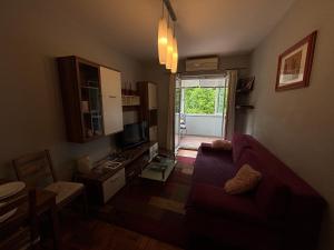 a living room with a red couch and a tv at Apartment T&T in Lovran