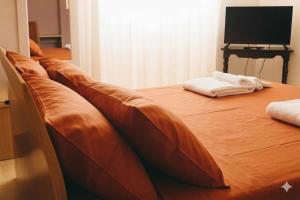 a bed with brown leather cushions in a room at Torres House Suite & Rooms in Sassari