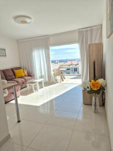 a living room with a couch and a vase of flowers at Valdés in Callao Salvaje